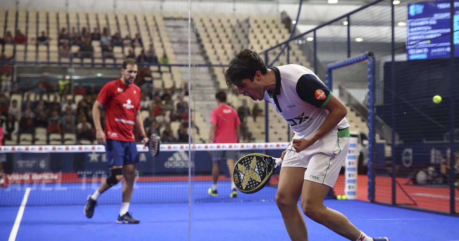 Joueur professionnel en blanc célébrant un point, tableau de score au fond, Vigo Open 2019
